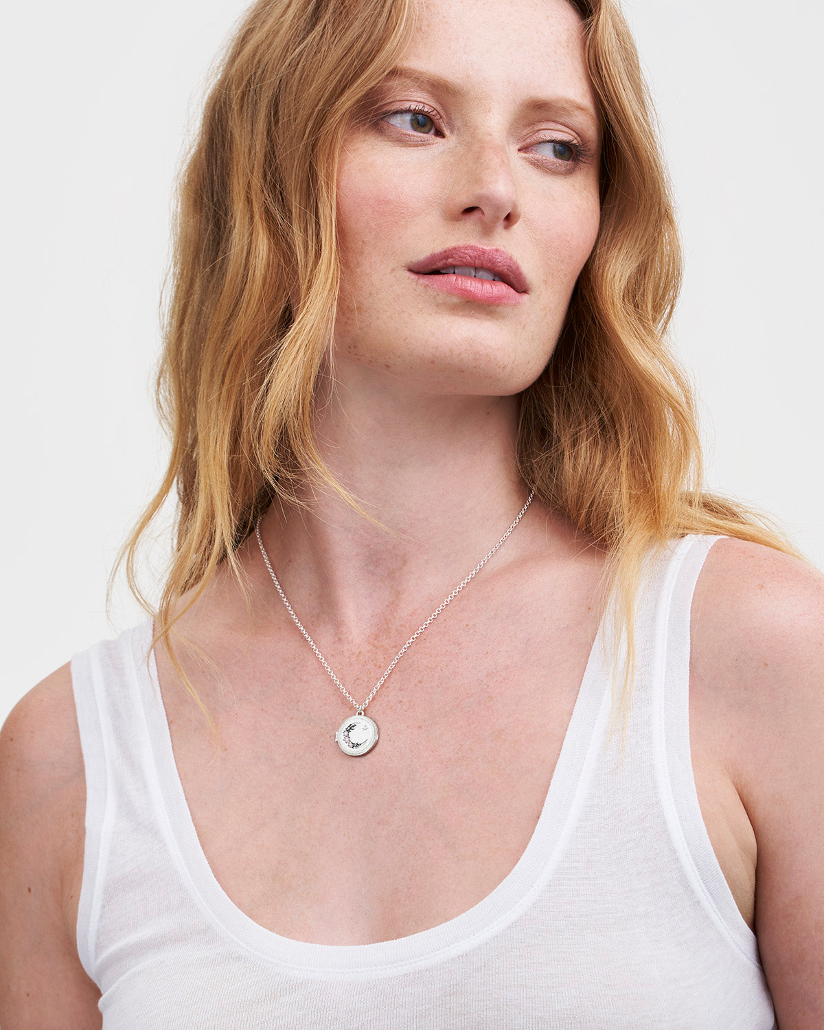 Women wearing a silver locket pendant necklace on white background