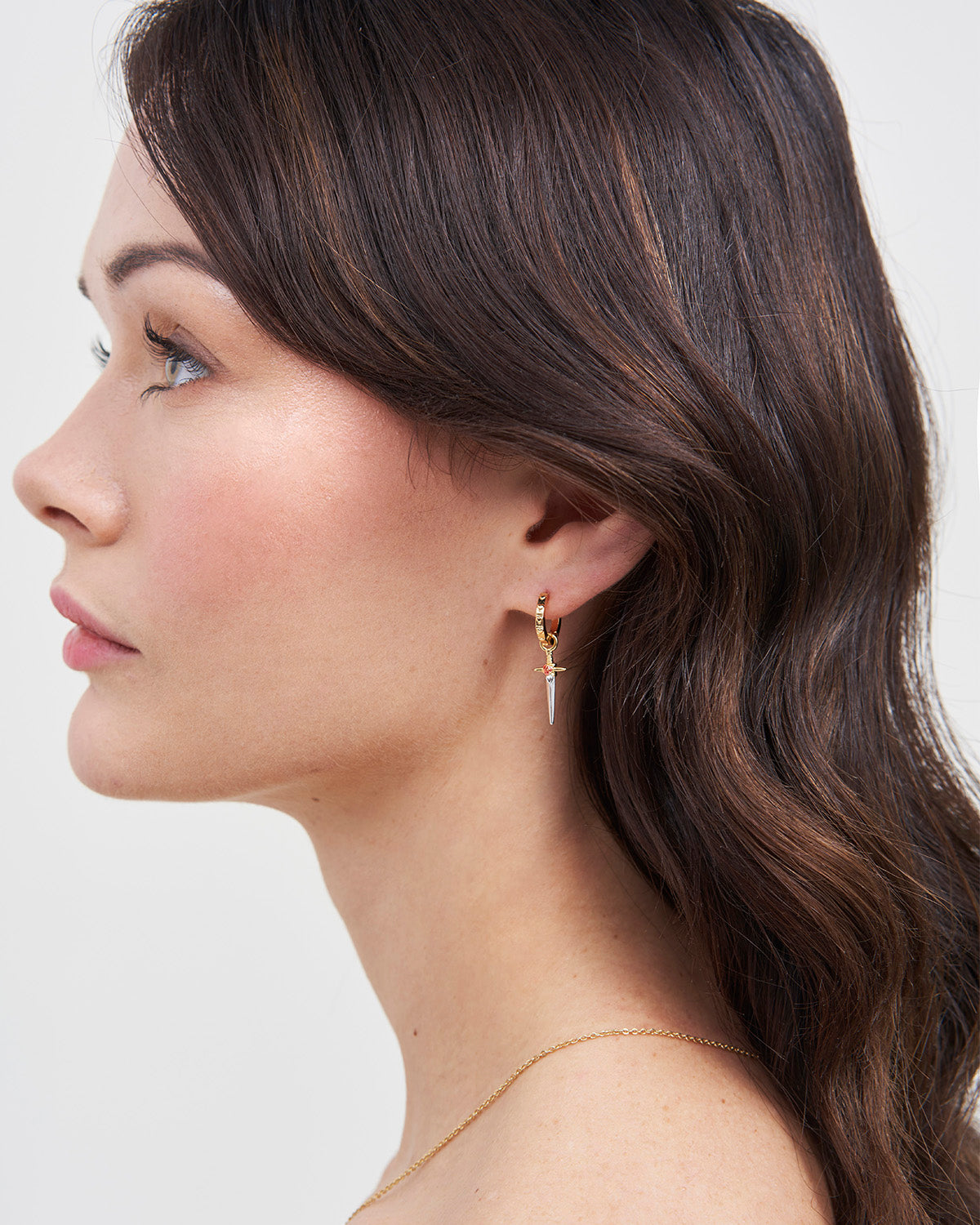 Gold Rose & Dagger Huggie Earrings on model