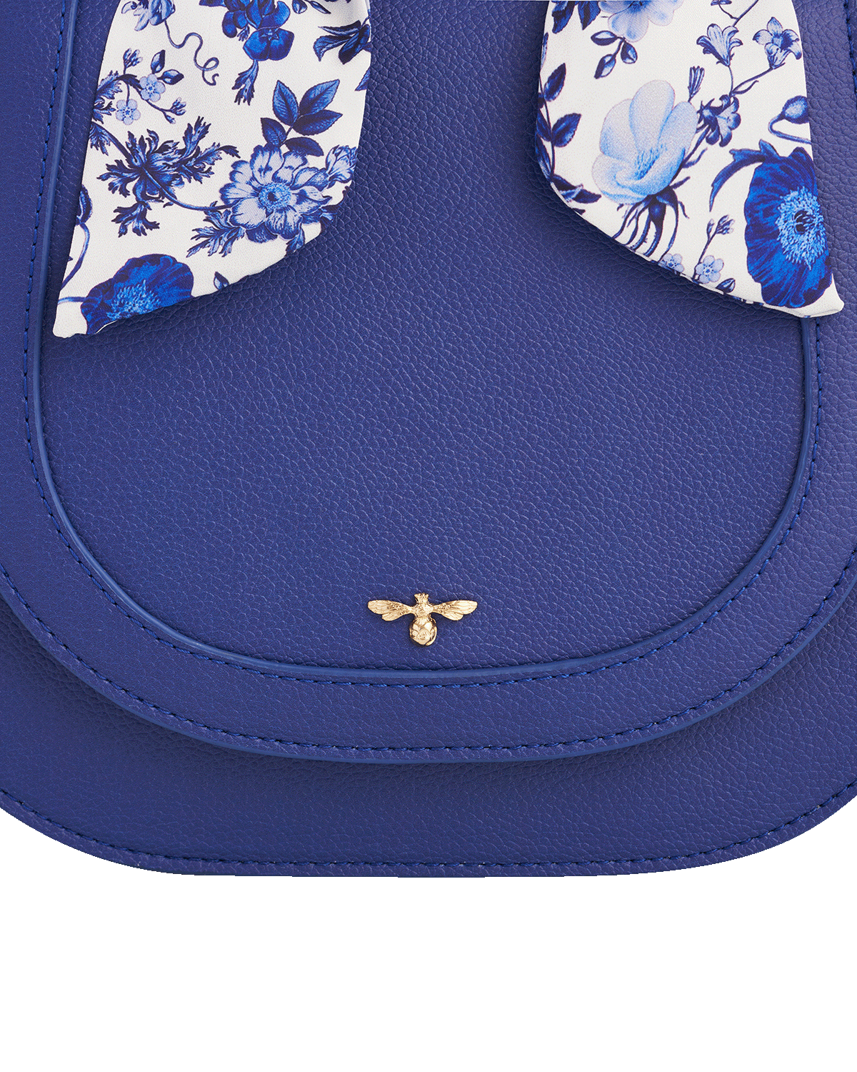 Blue handbag with floral accents and a gold bee emblem on a white background