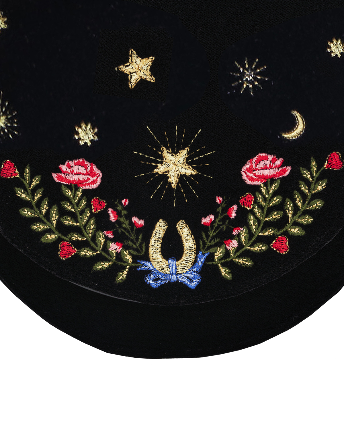 Embroidered design on a black background with flowers, horseshoe, and stars.