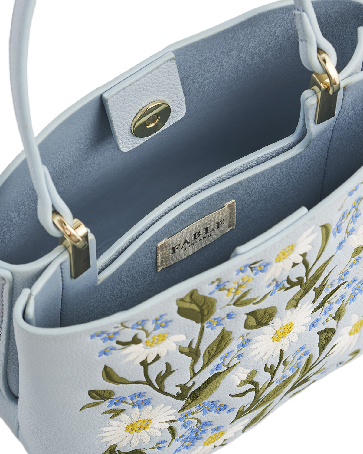 Floral embroidered handbag with 'Fable' label on a light blue background