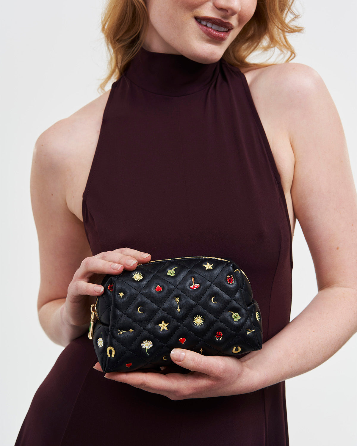 Woman holding the Black Quilted Celestial Embroidered Pouch on white background