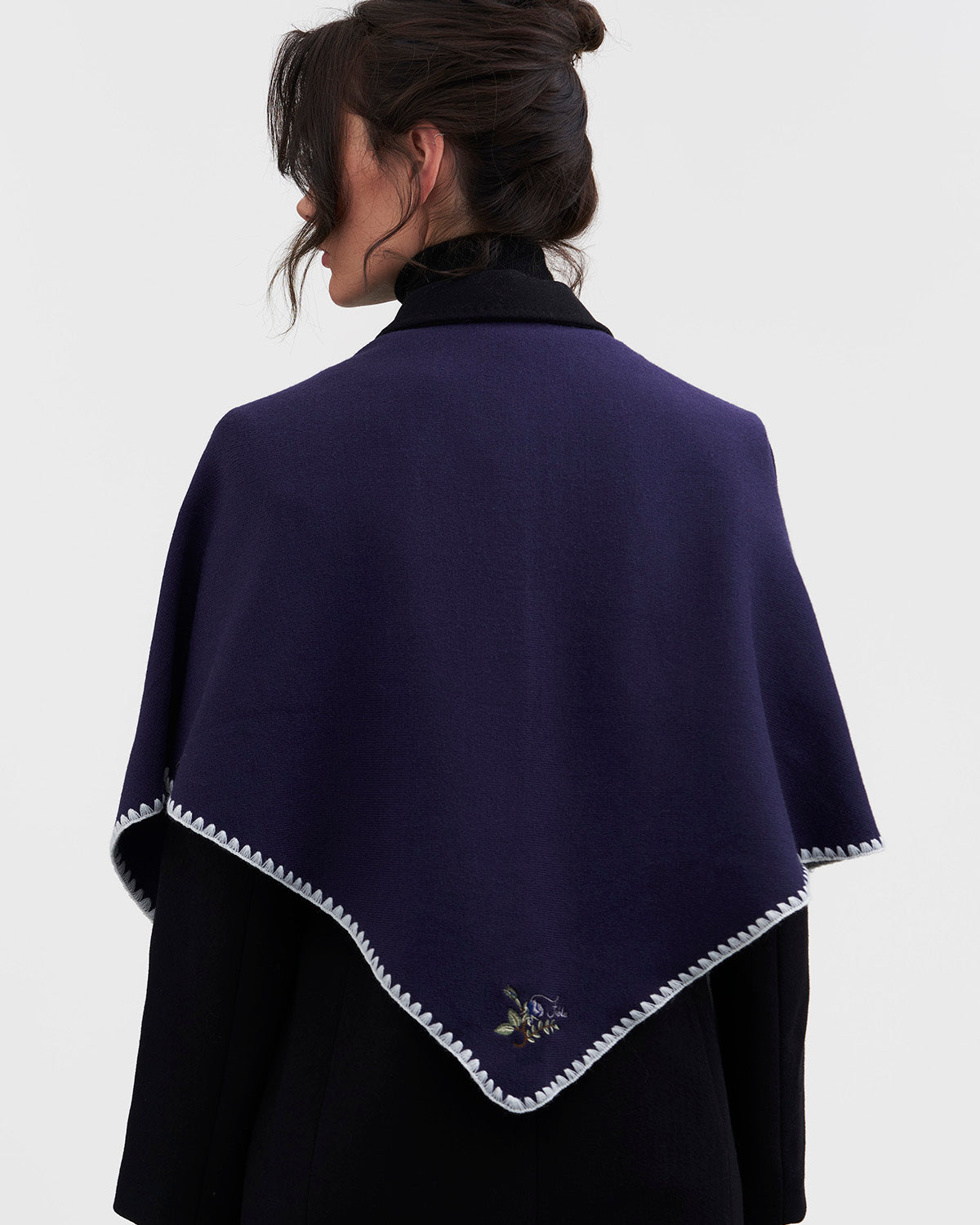 Woman wearing a dark blue scarf with white trim on a white background