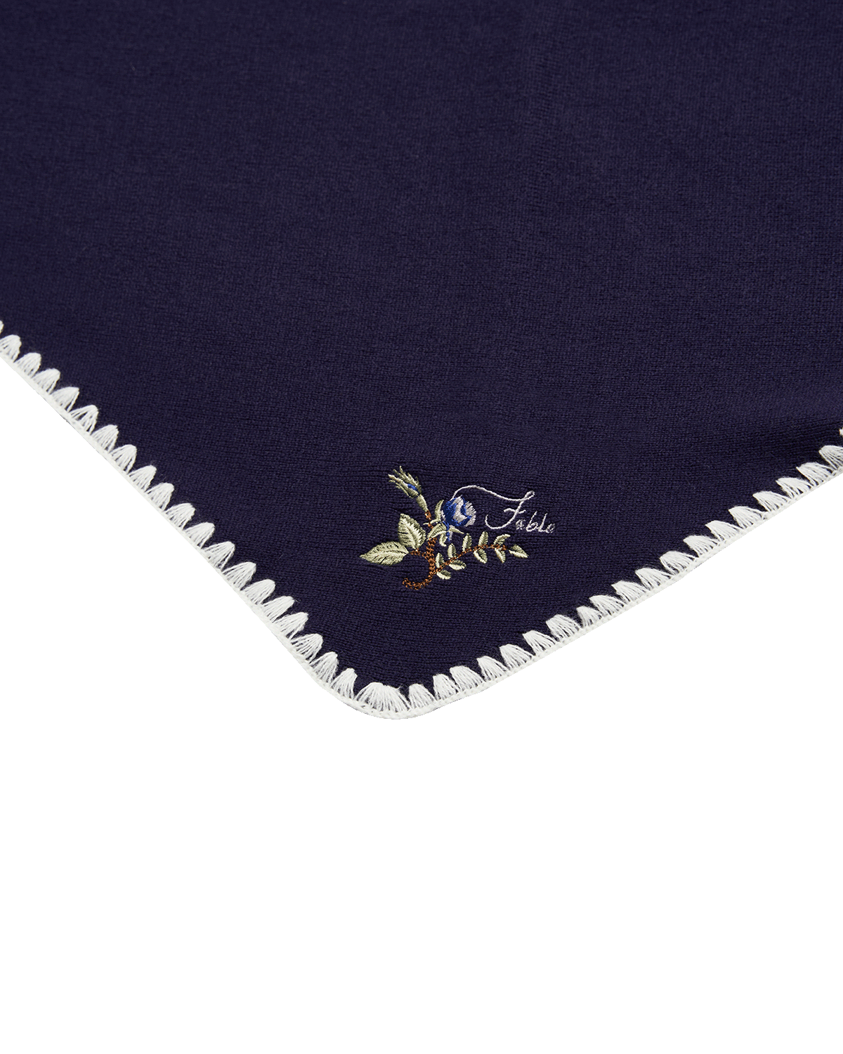 Navy blue fabric with embroidered floral design and Fable brand logo on a white background