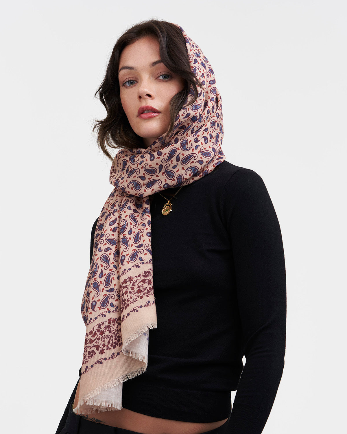 Woman wearing a patterned scarf on a white background