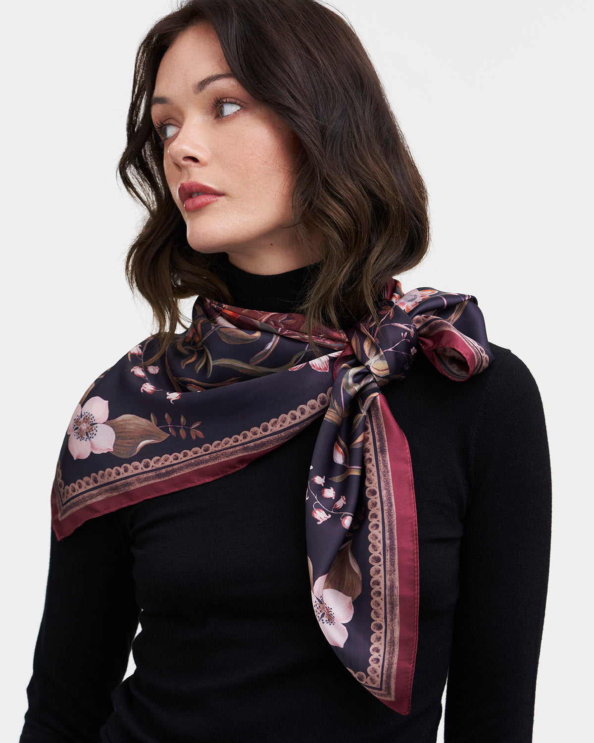 Woman wearing a floral patterned scarf on a white background