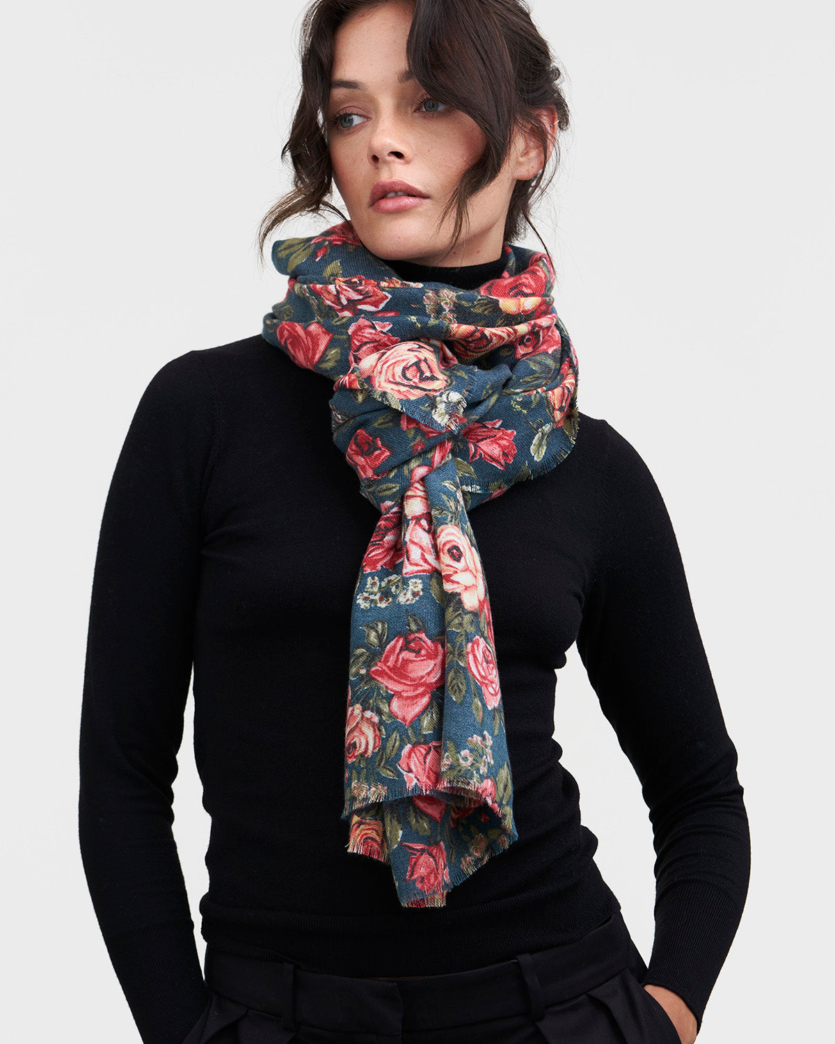 Woman wearing a floral scarf on a plain background