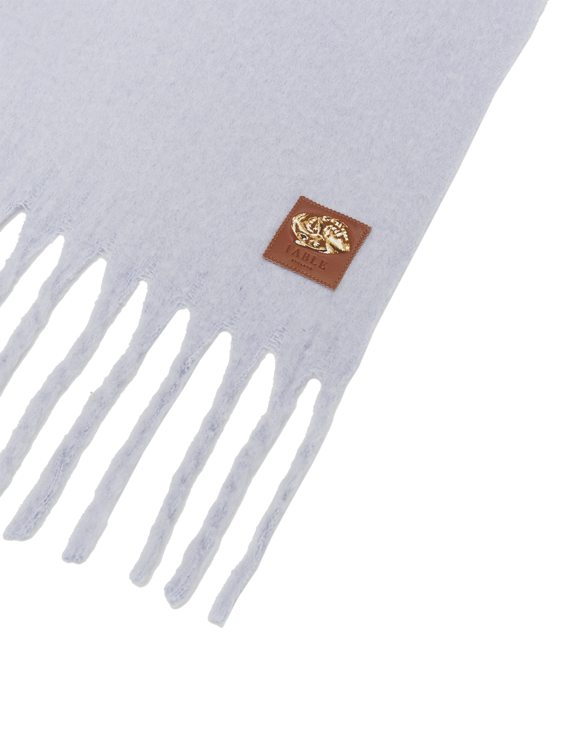 Gray scarf with white fringe and a brown logo patch on a light gray background