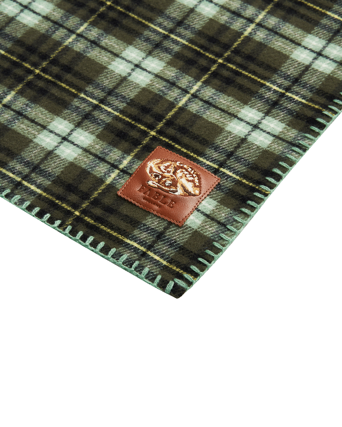 Plaid fabric scarf with a brown leather patch featuring a sleeping fawn embroidered motif on a white background