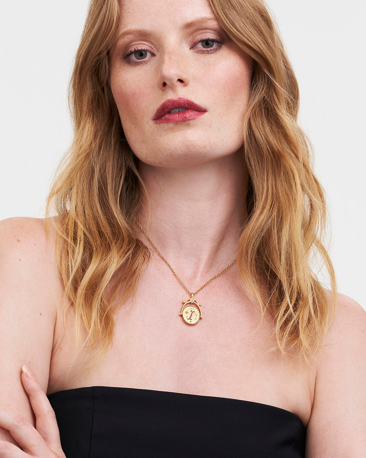 Collar giratorio dorado con inicial “I” y flor de iris