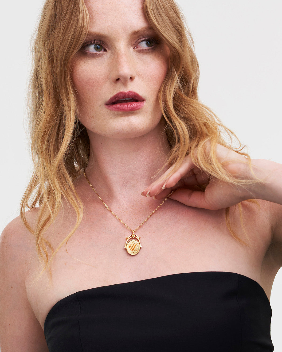 Collar giratorio dorado con inicial U y flor Ursinia