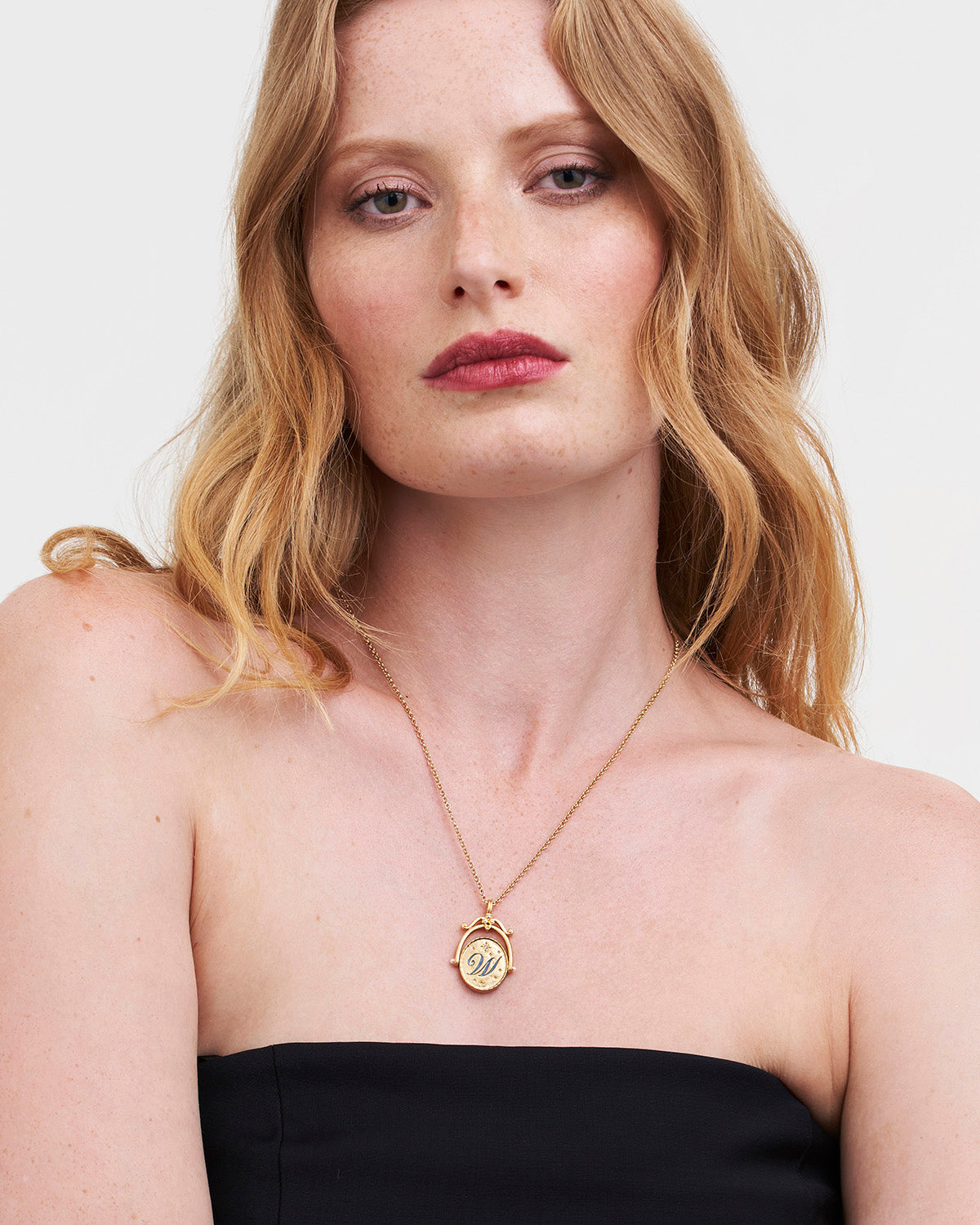 Collar giratorio dorado con inicial W y lirio de agua
