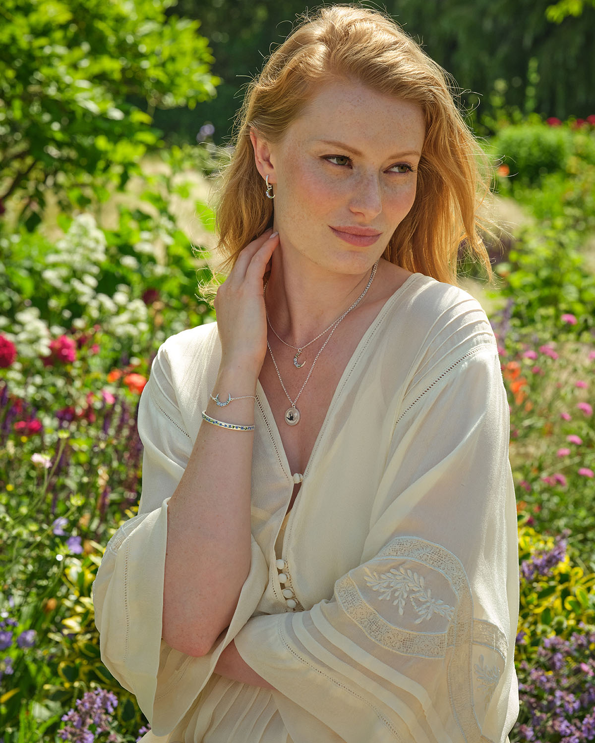 Woman in a white dress standing in a garden with flowers