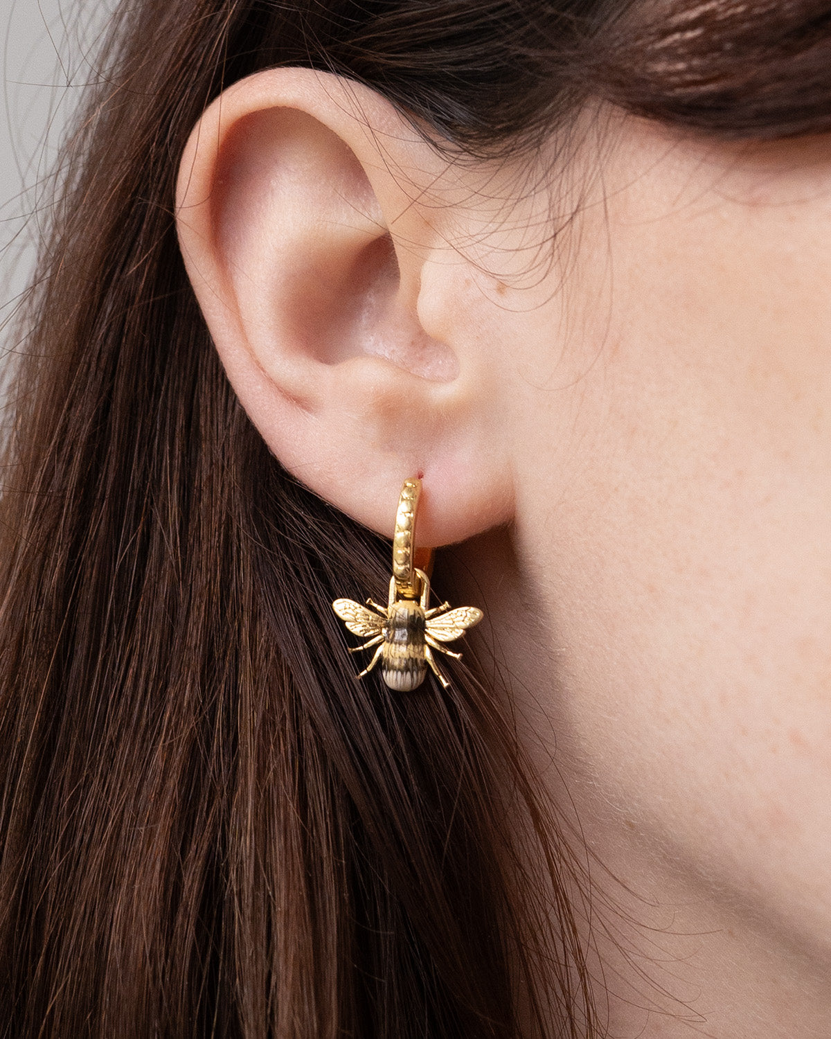 Enamel Bee huggie earrings on model
