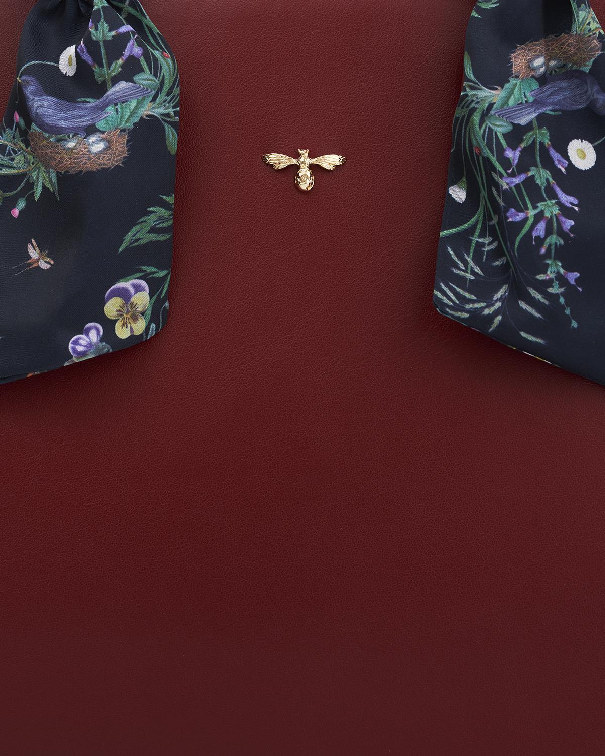 Navy fabric with floral and bird design on a red background