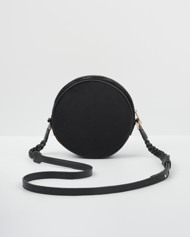 Back of embroidered sleepy fox motif on navy circle crossbody bag. Back is plain.