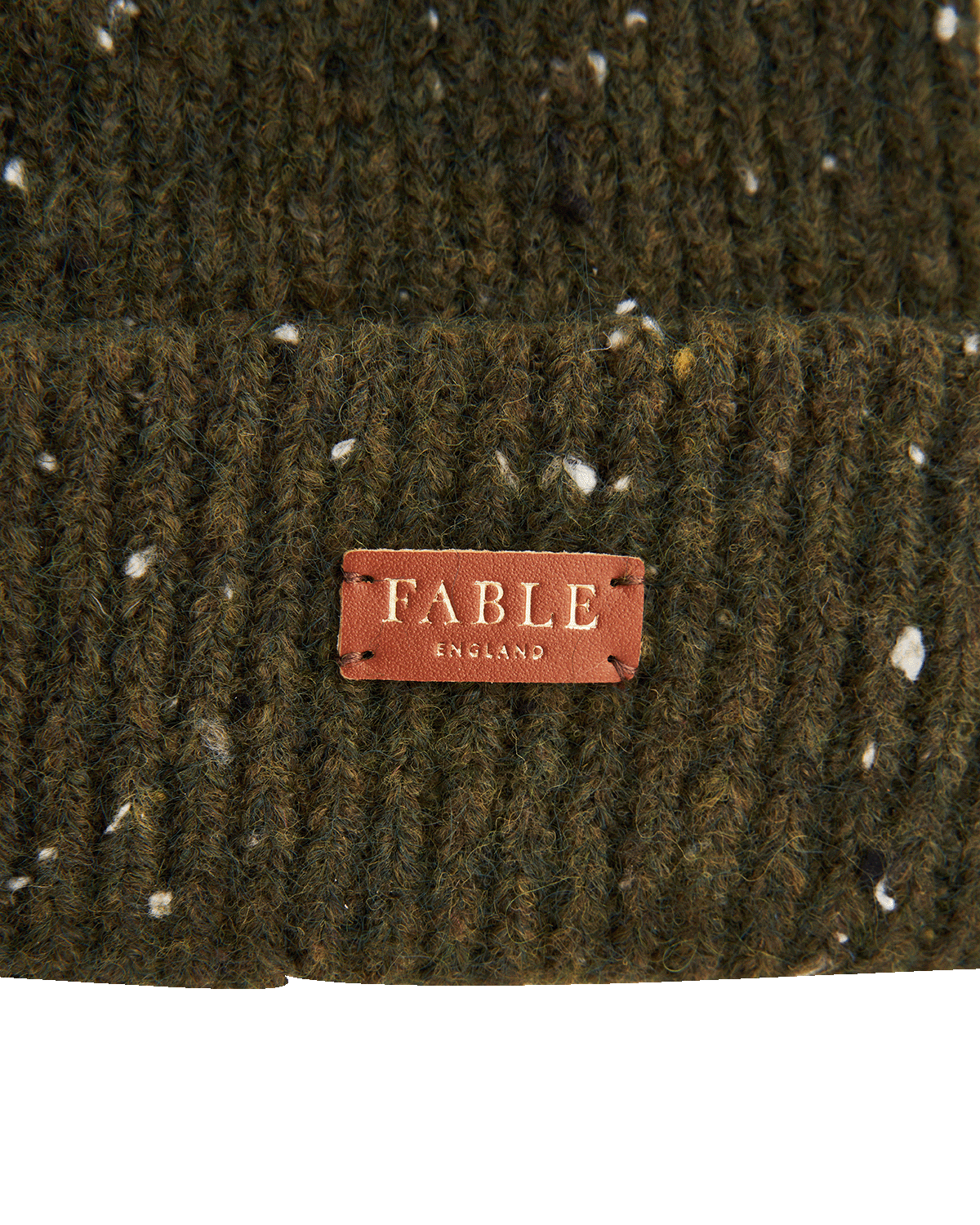 Close-up of a green knitted fabric with a 'Fable England' label.