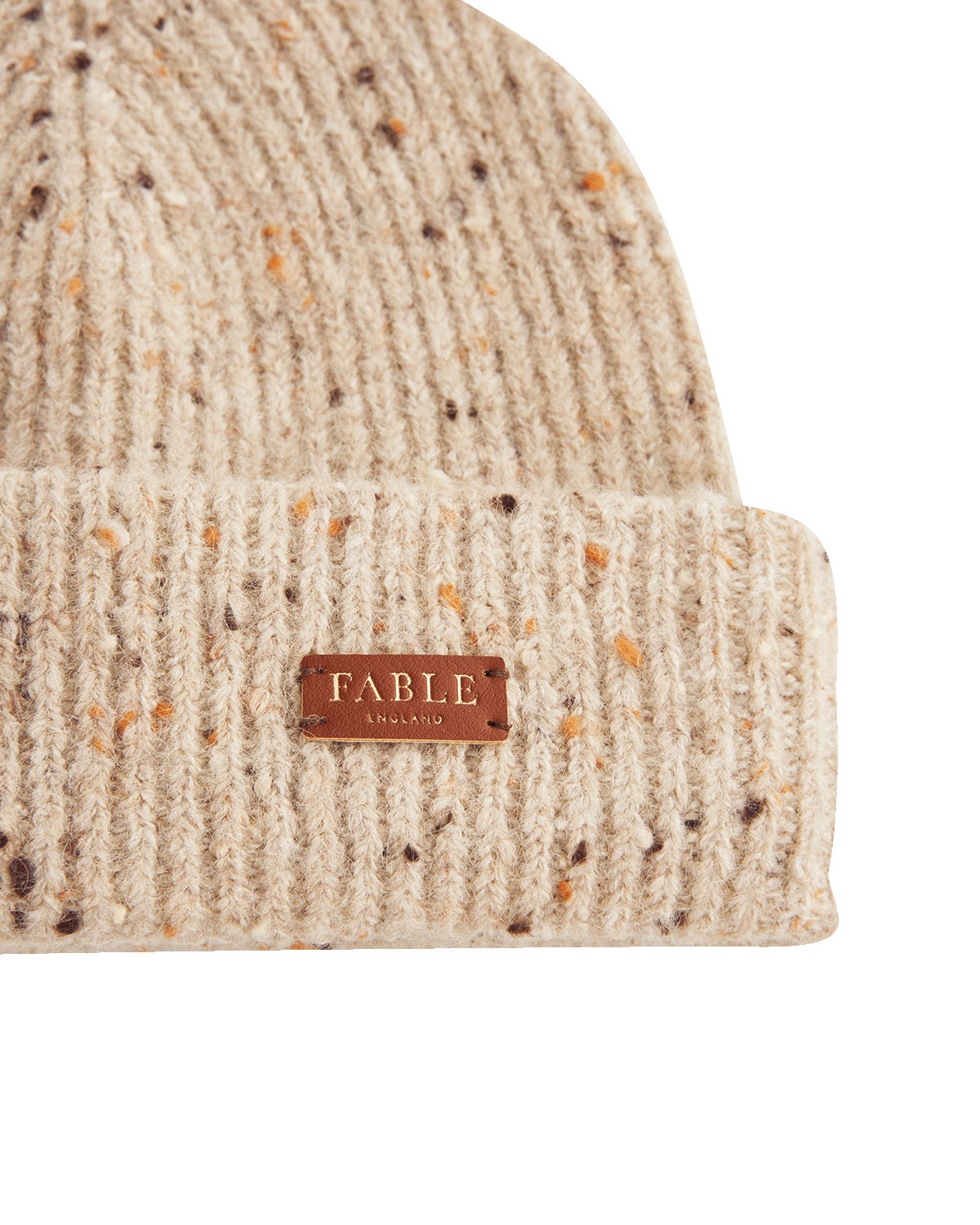 Taupe knit beanie with a brown alternative leather label on a white background
