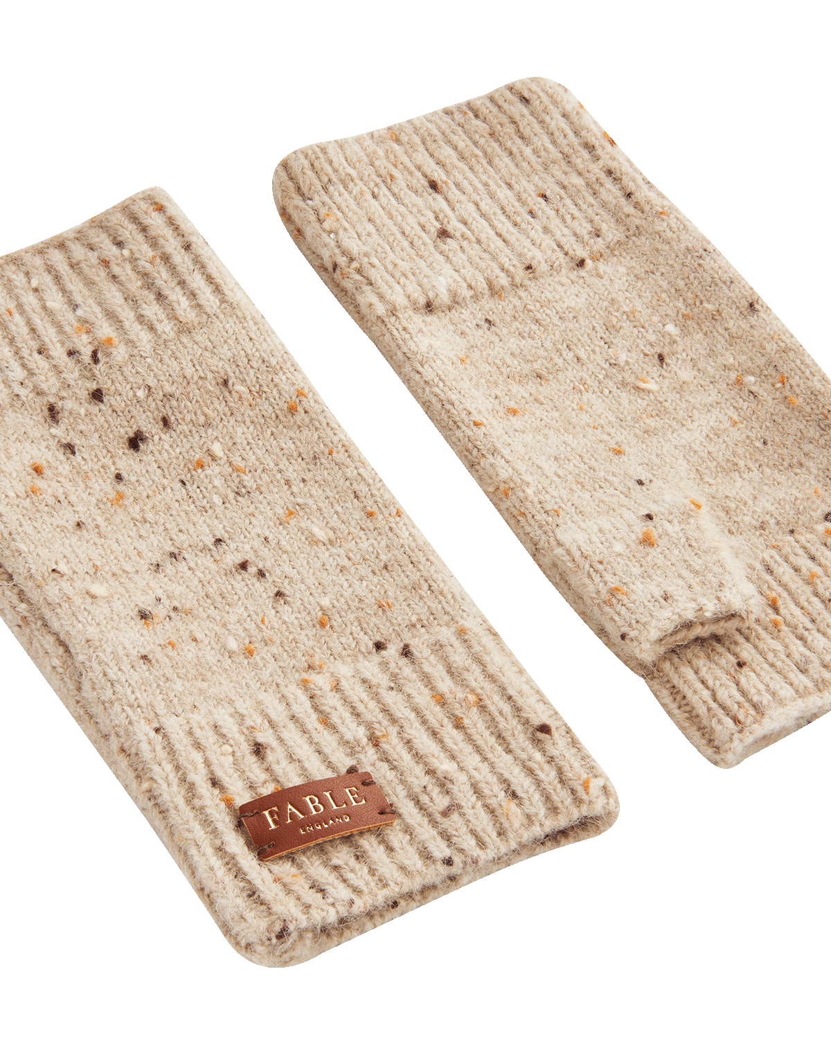 Pair of beige knitted fingerless gloves with Fable England brand label on a white background