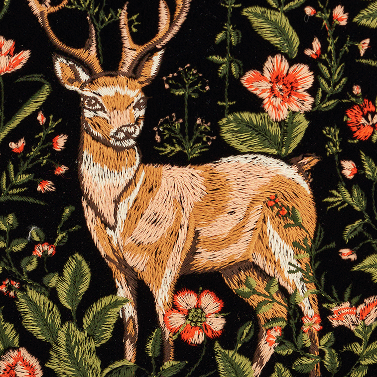 Embroidered design of a deer surrounded by flowers on a black background