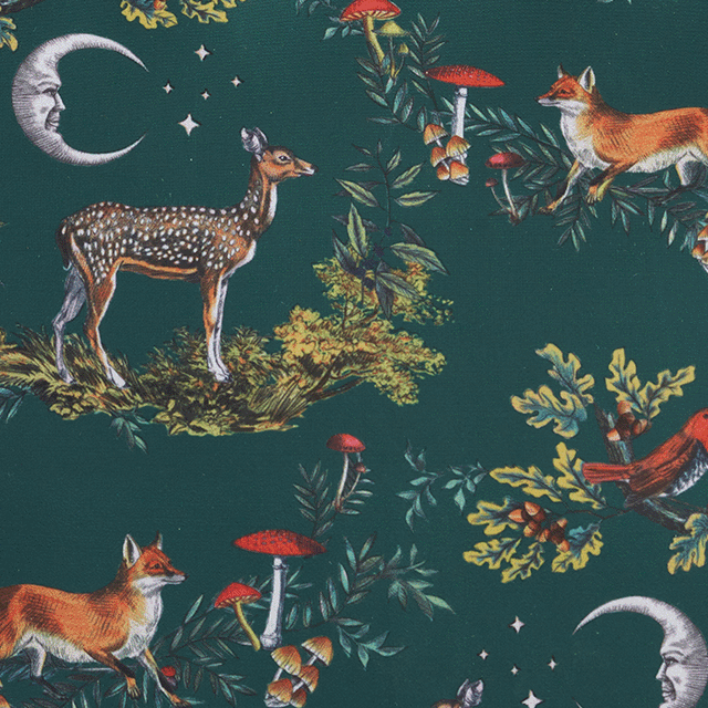 Patterned fabric with forest animals and plants on a dark green background