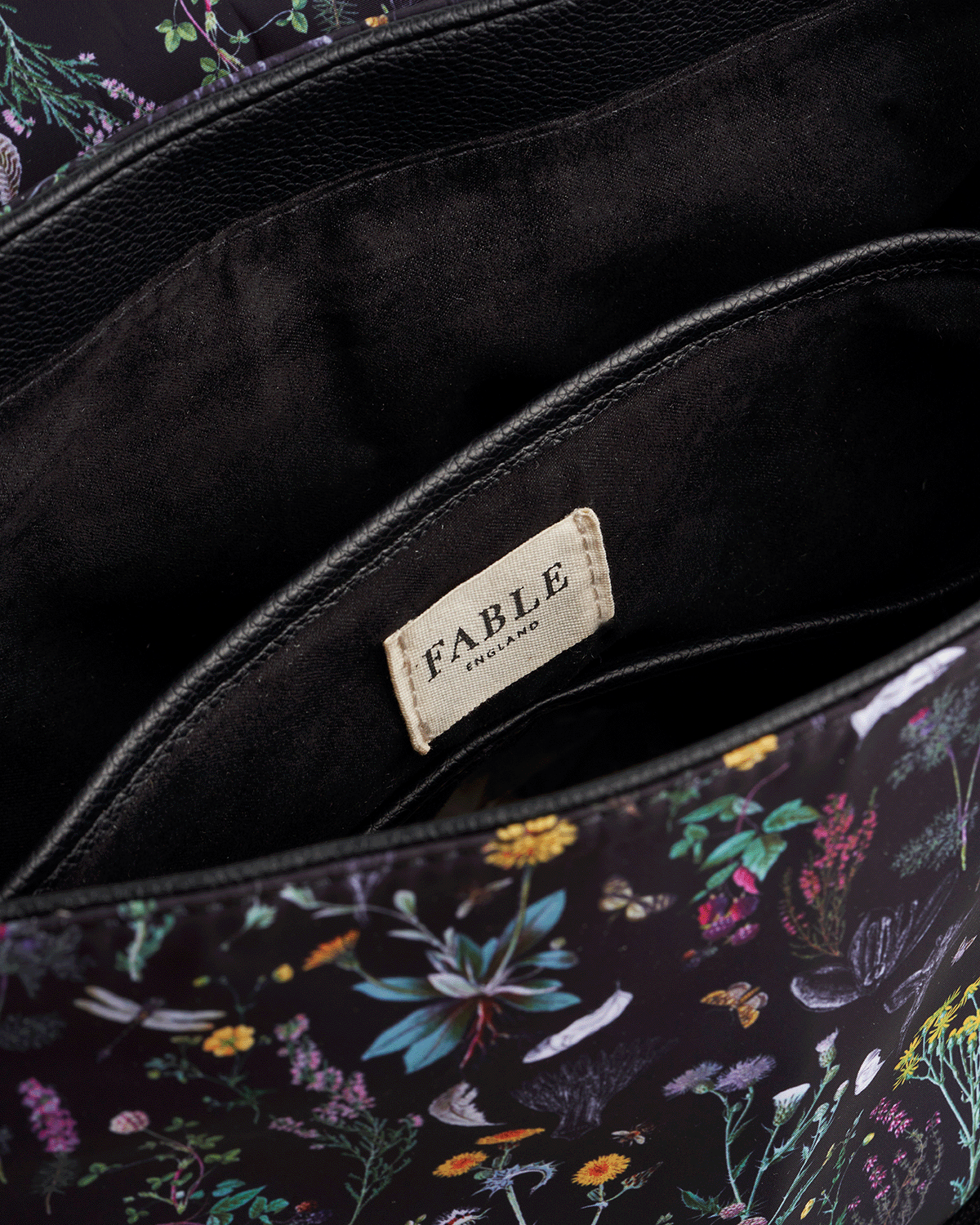Floral-patterned bag with 'Fable England' label on a dark background