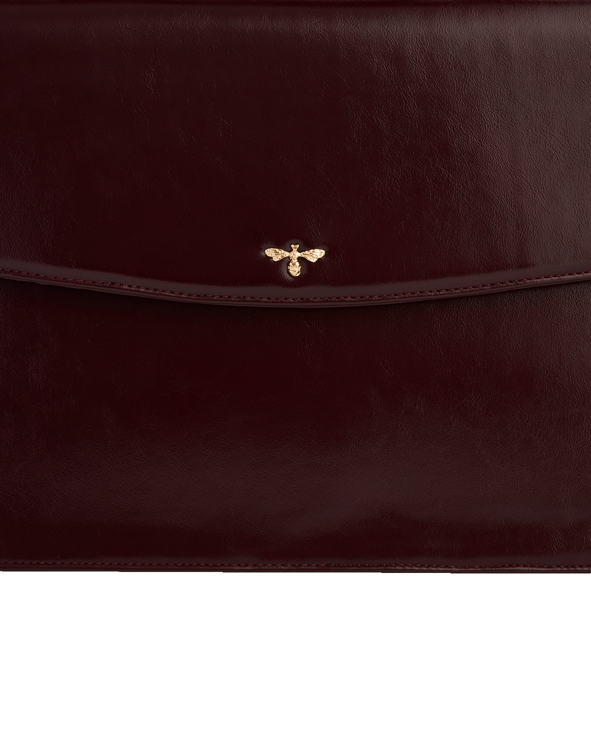 Cherry red leather clutch bag with a gold bee emblem on a white background