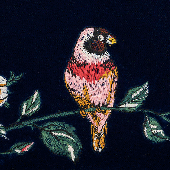 Navy blue fabric with embroidered birds and flowers on a white background