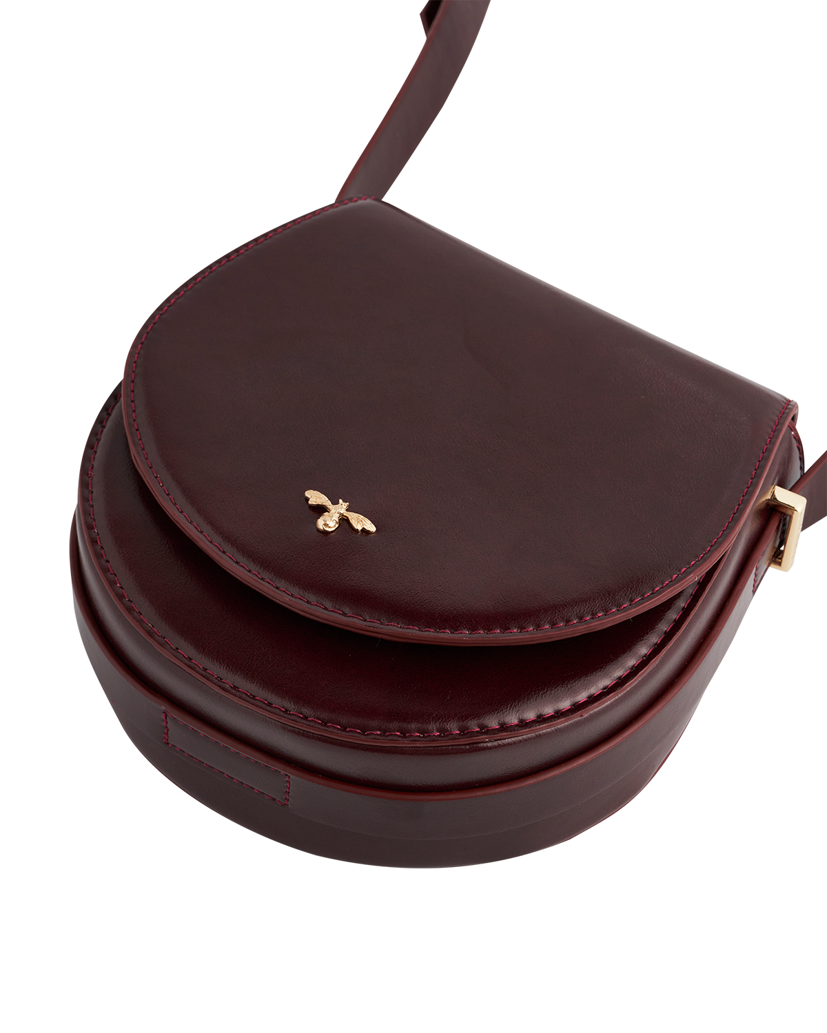 Cherry red leather handbag with a gold bee emblem on a white back grounded
