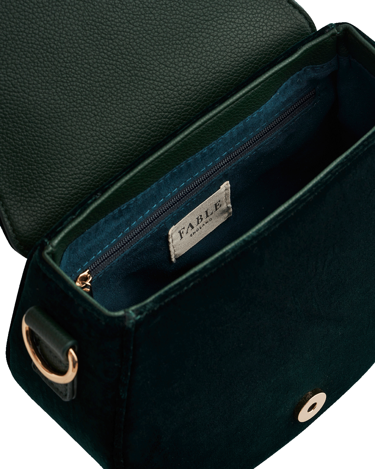 Close-up of a green handbag with a Fable England brand label on a white background