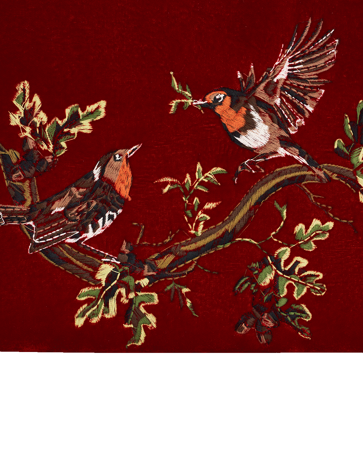 Embroidered design of two birds on a branch with leaves against a red background