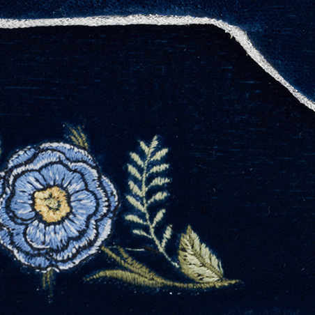 Navy blue fabric with floral embroidery and a silver buckle.