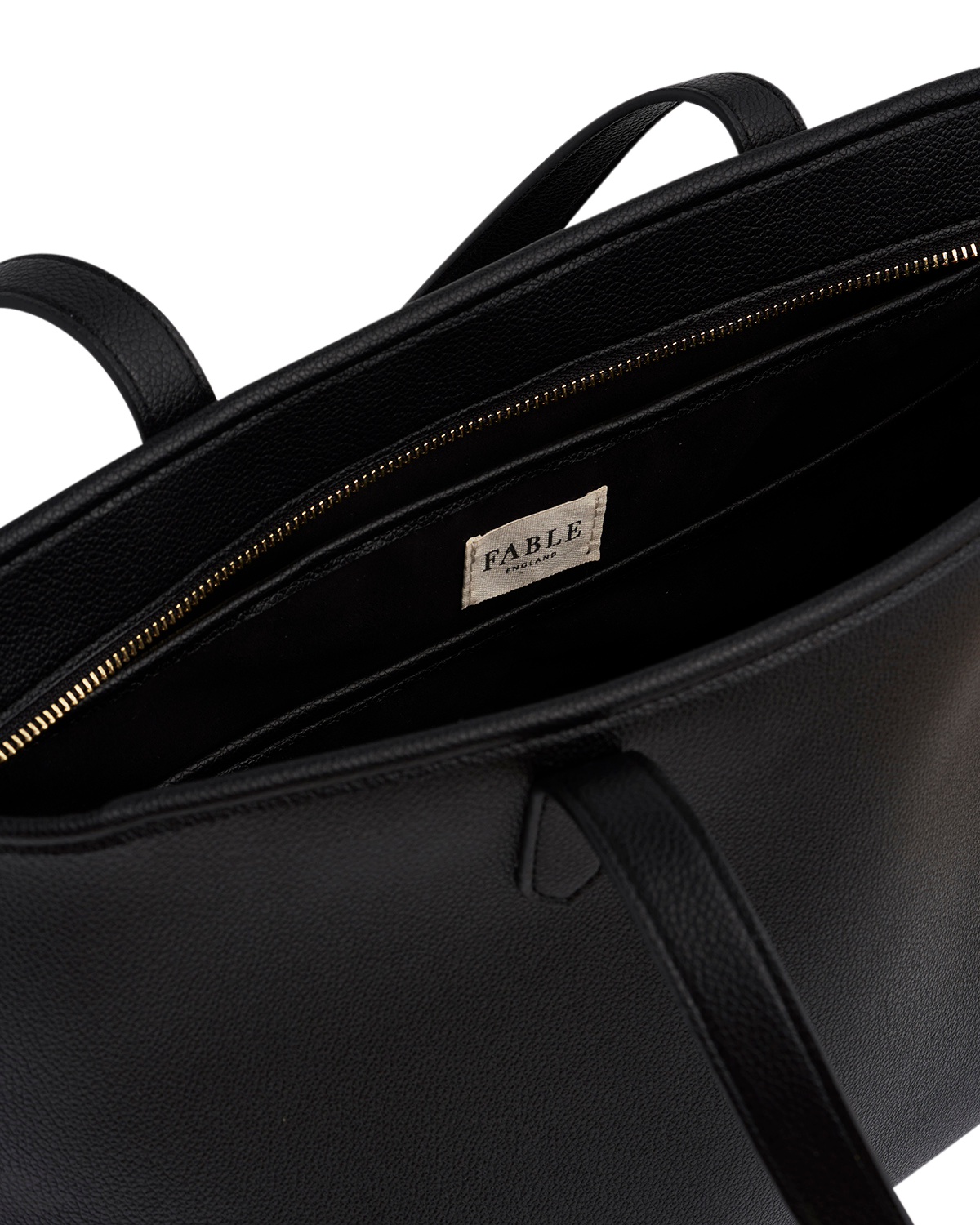 Close-up of a black leather bag with 'Fable' branding on a white background