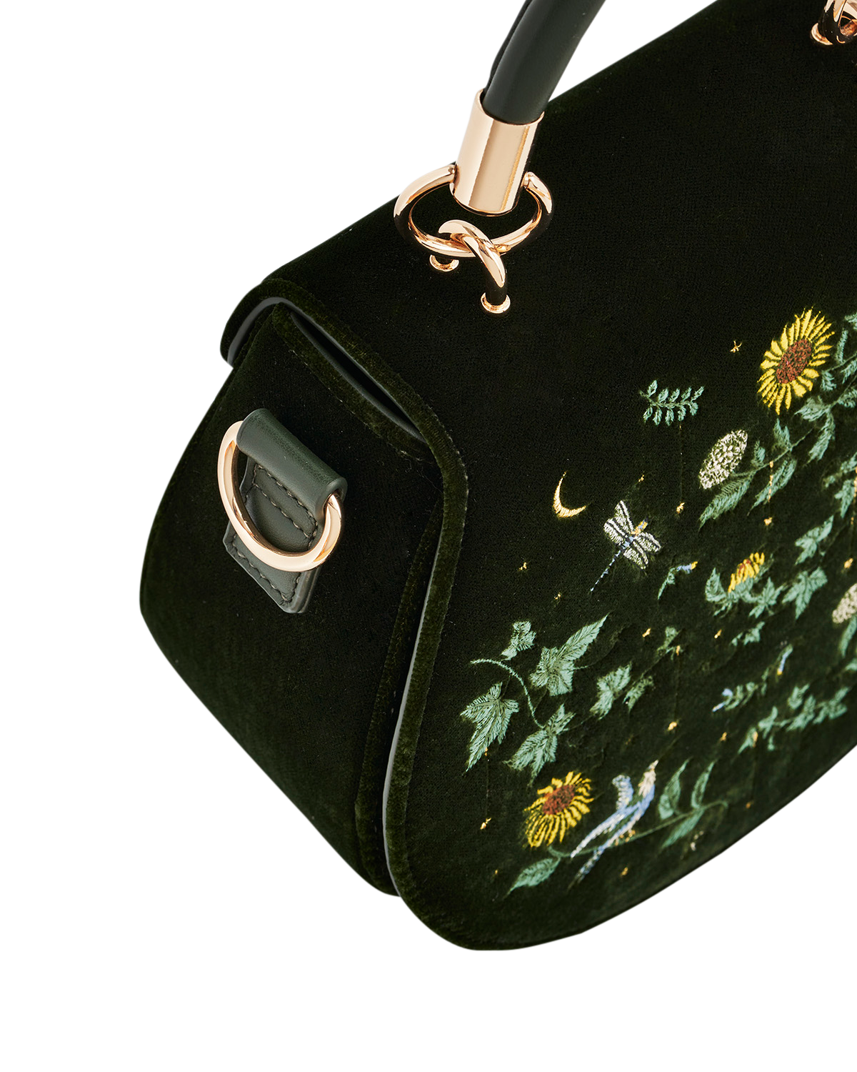 Green handbag with floral embroidery on a white background