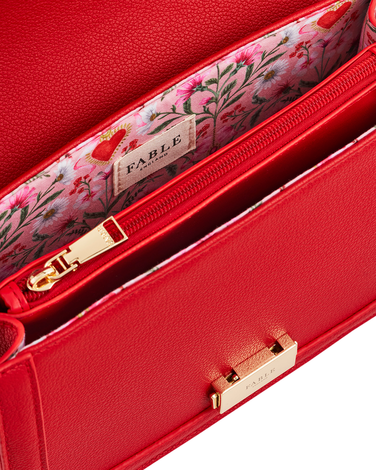 Red handbag with floral interior and 'Fable' brand label.