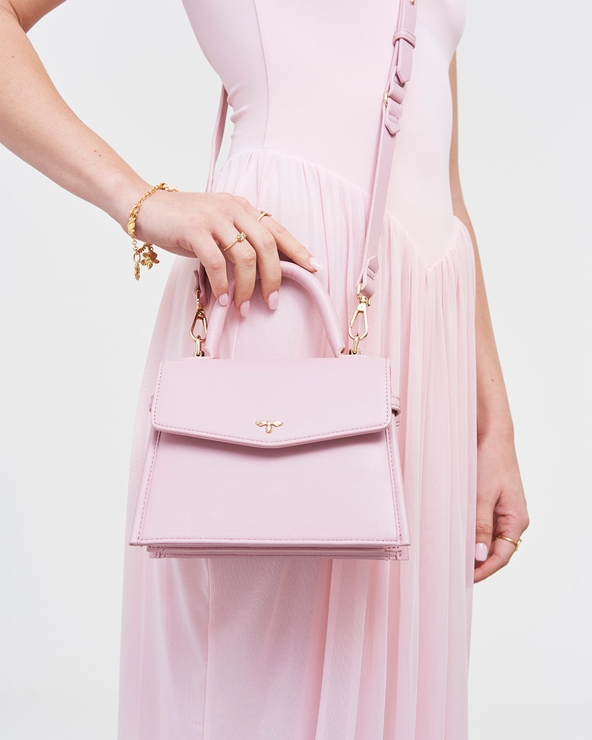 Person holding a pink handbag with a white background