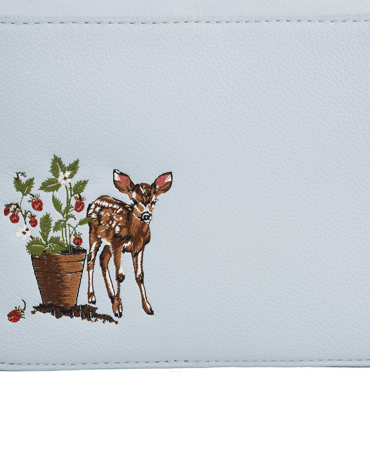Embroidered design of a deer and potted plant on a light blue background