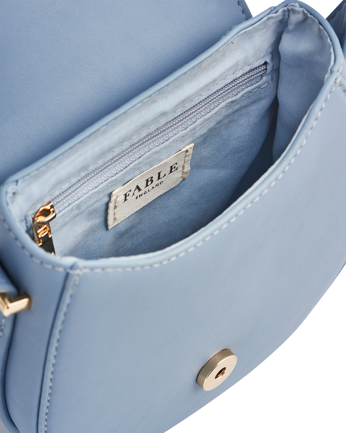 Light blue handbag with gold accents and 'Fable' brand label on a white background