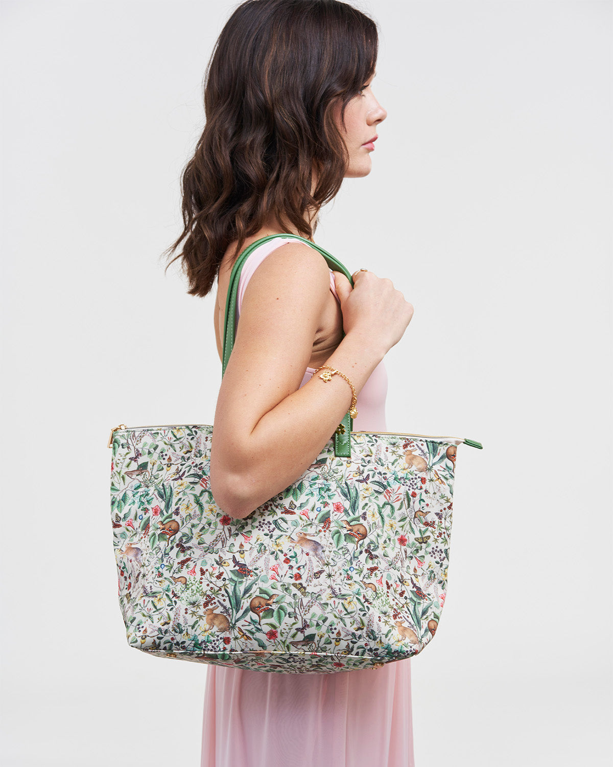 Woman holding a floral-patterned tote bag against a plain background