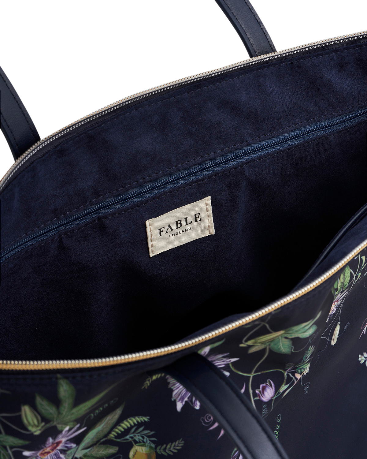 Navy blue bag with floral pattern and 'Fable' brand label on a white background