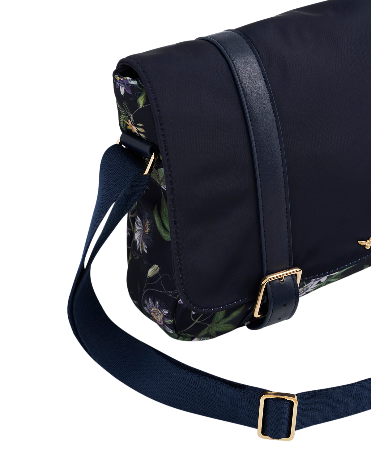 Navy blue bag with floral pattern on flap and gold buckle on strap against a white background