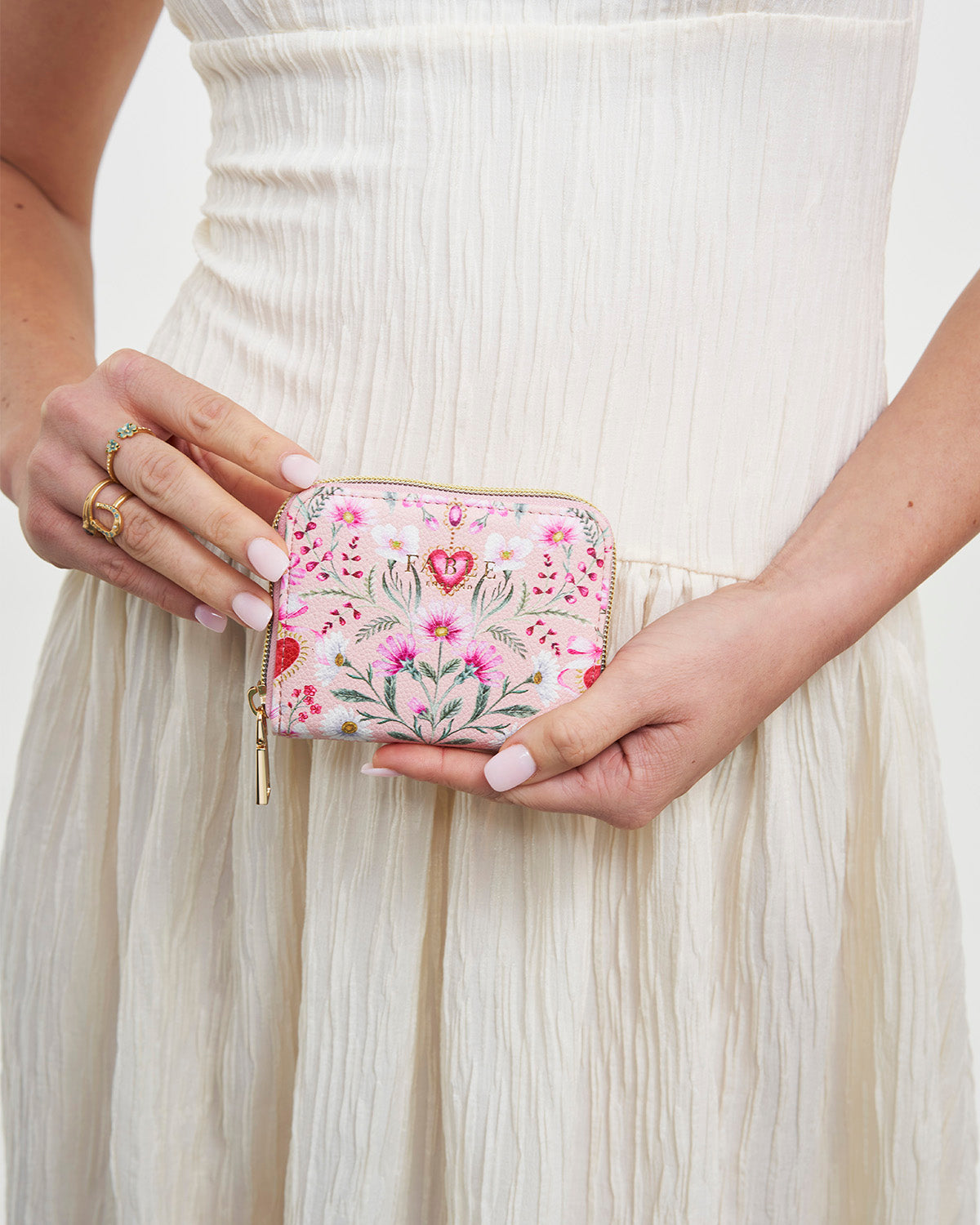 Person holding a floral wallet with a light background