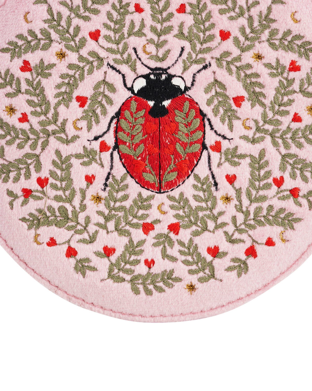 Embroidered ladybug design on a pink fabric background