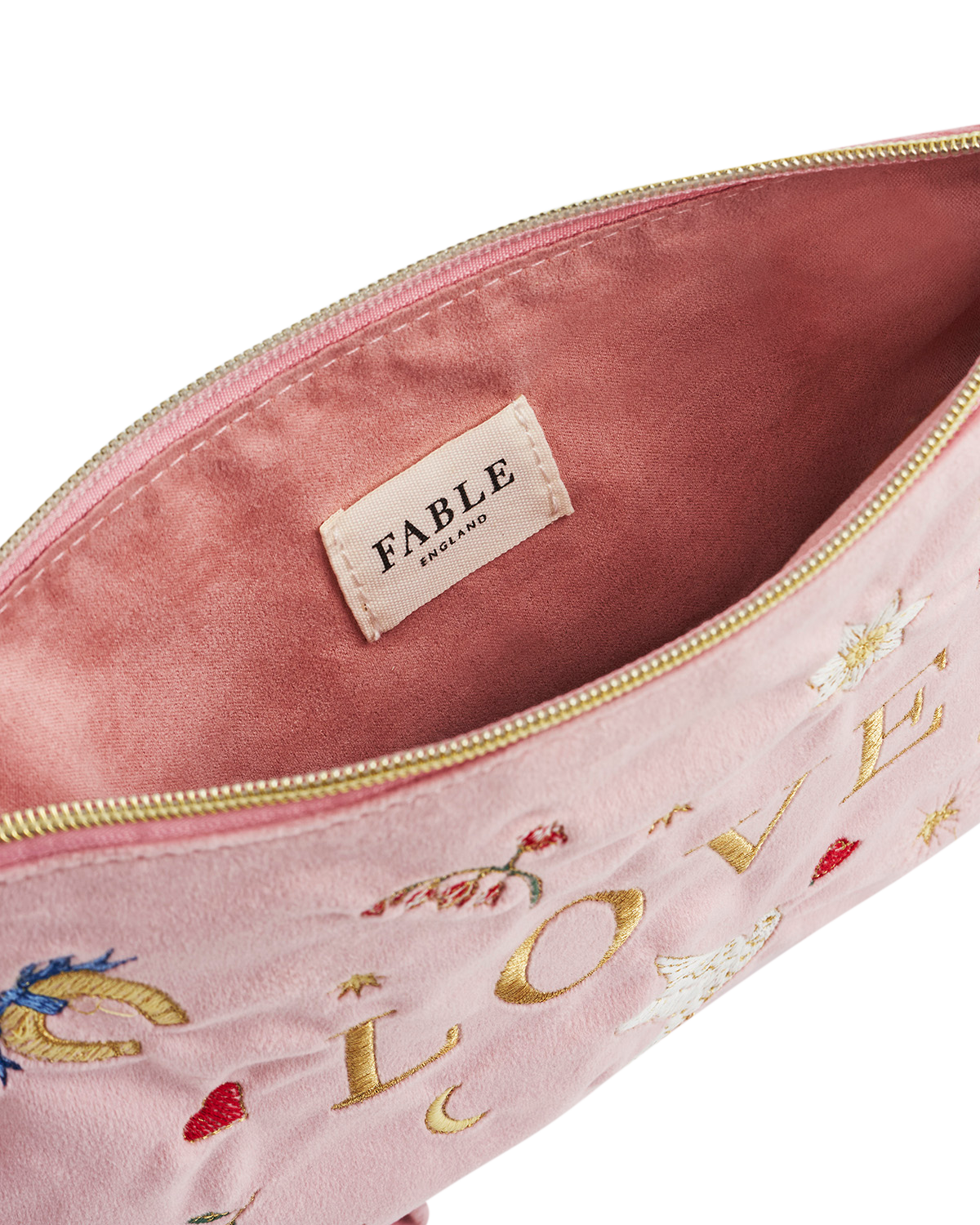 Pink pouch with 'Fable' branding and floral embroidery on a white background
