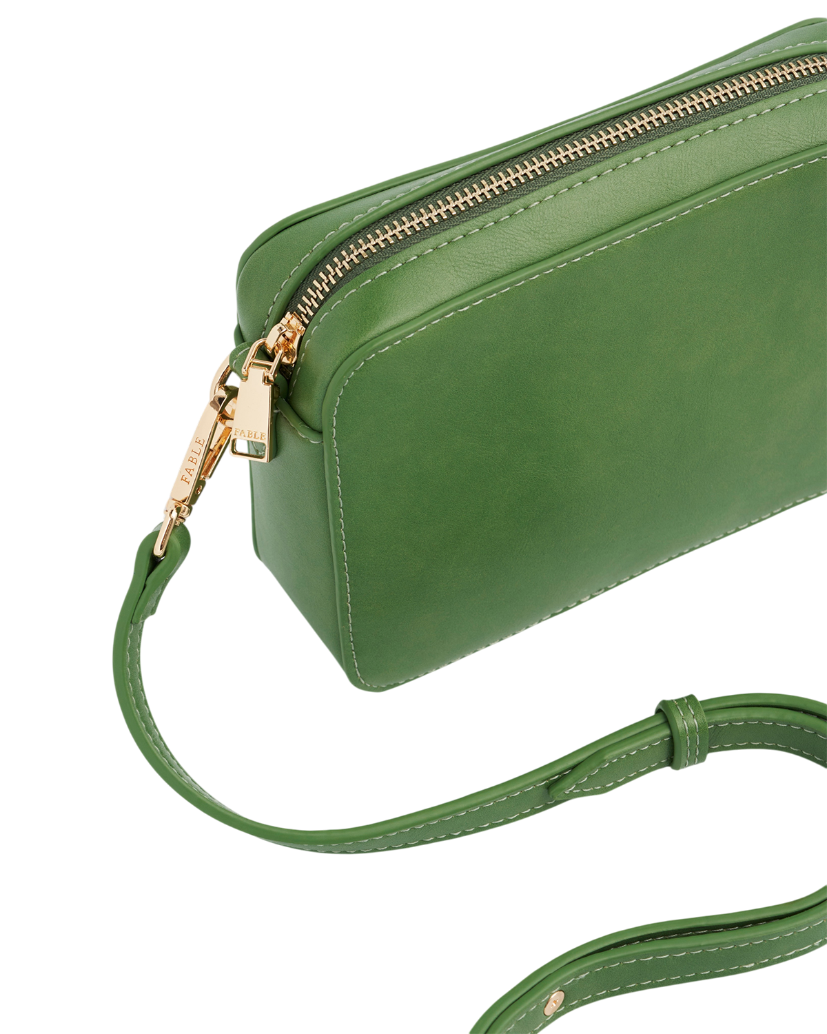 Green leather handbag with gold zipper on a white background