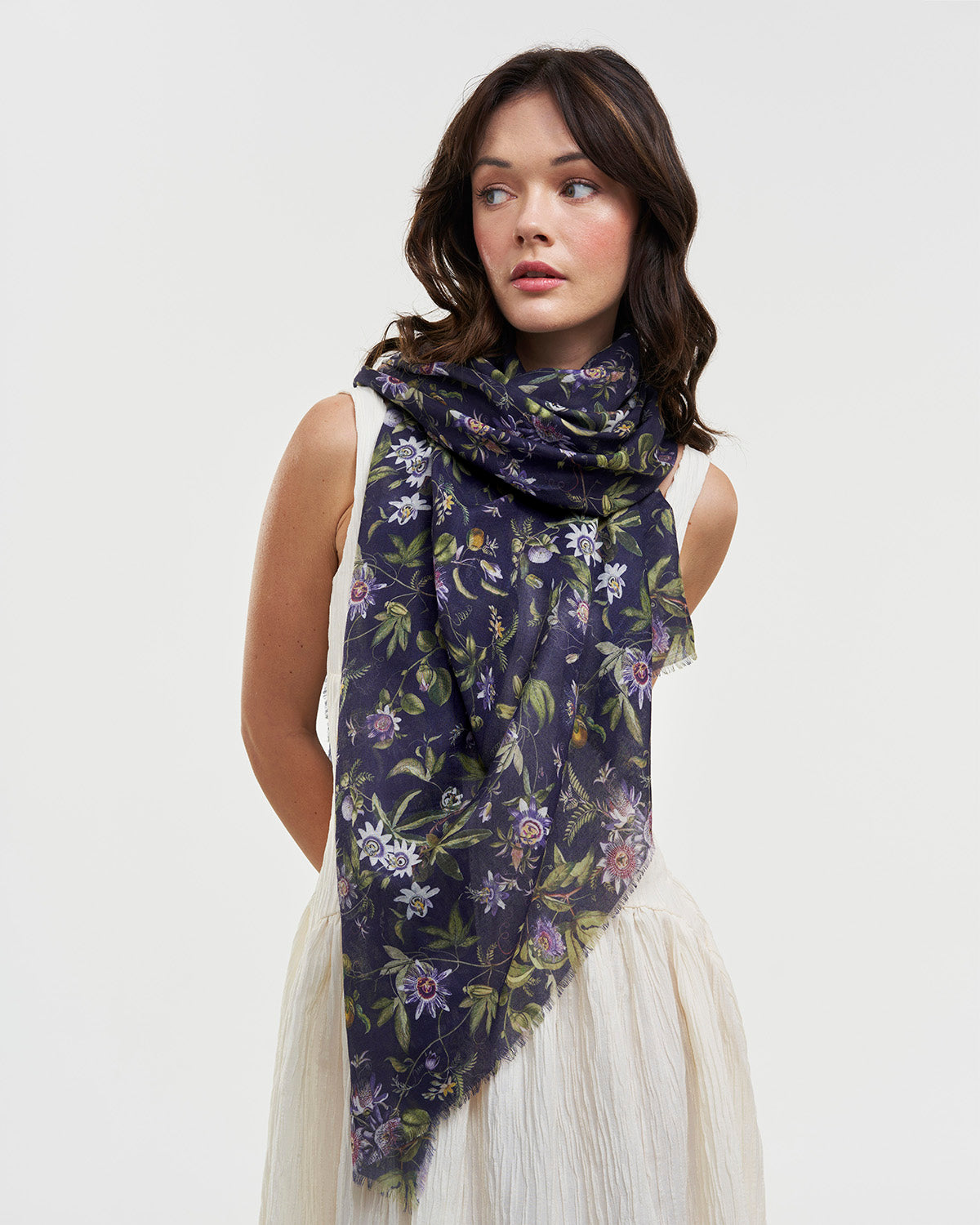 Woman wearing a floral scarf on a plain background