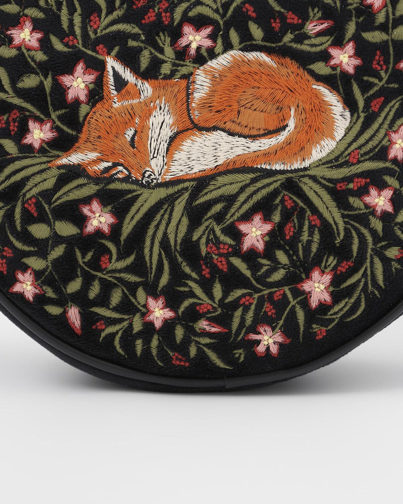Close up detail of embroidered sleepy fox motif on navy circle crossbody bag.