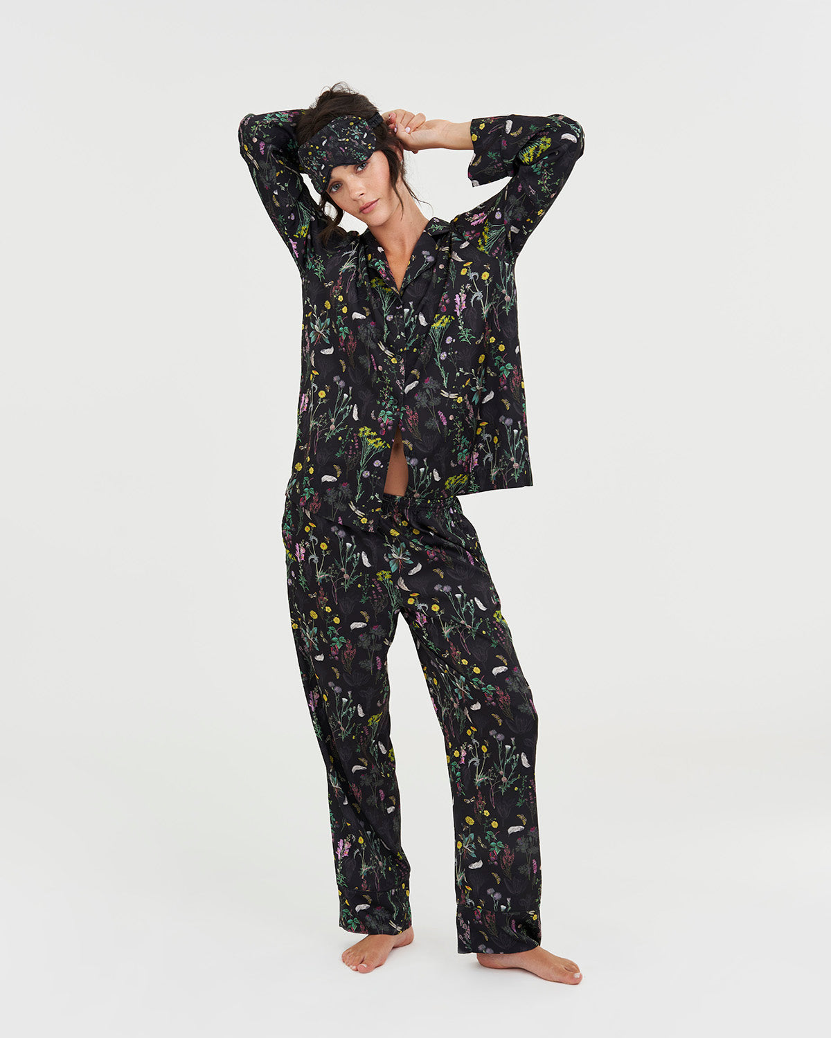 Woman wearing a black floral pajama set on a white background