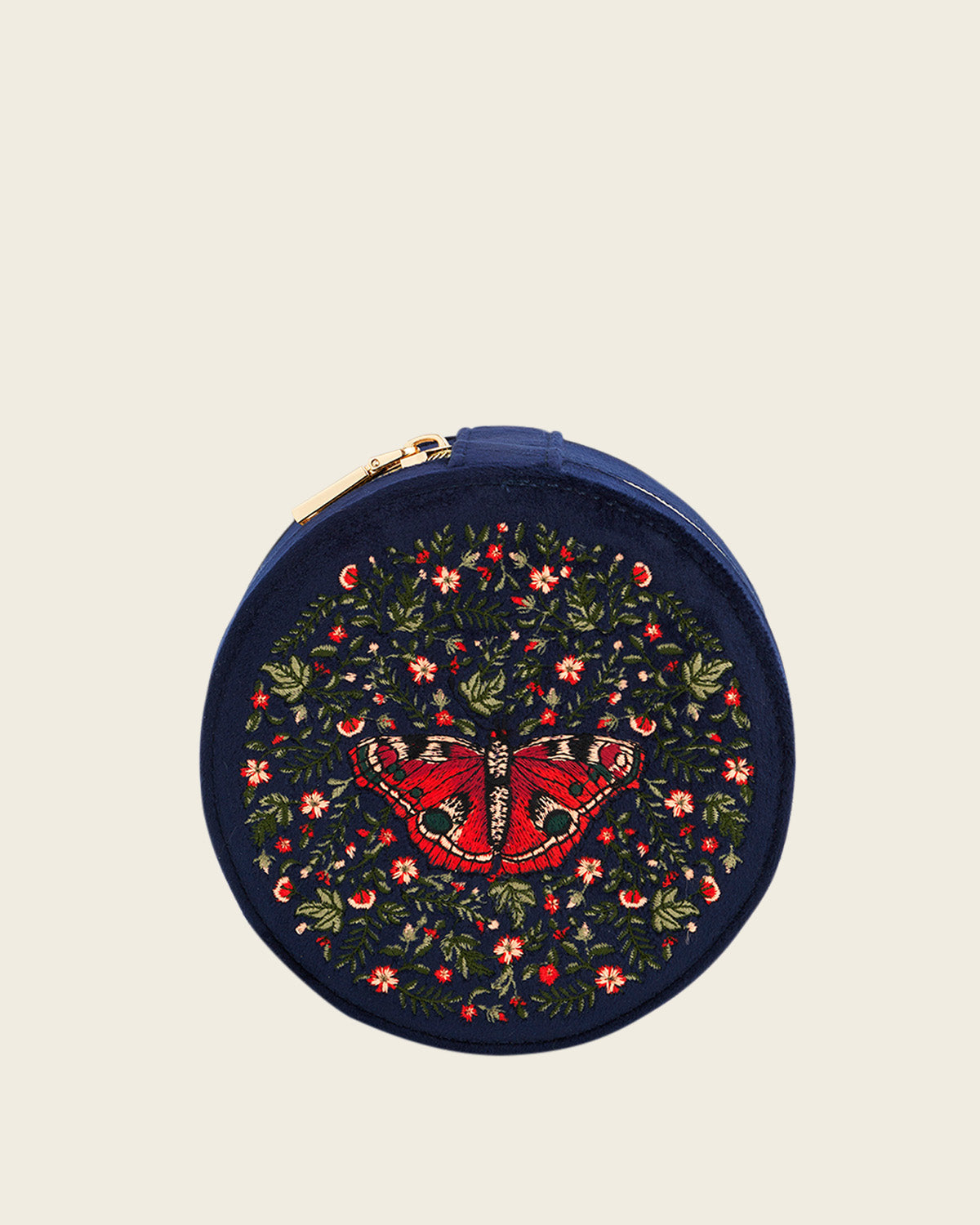 Round embroidered jewellery case with butterfly design on a beige background