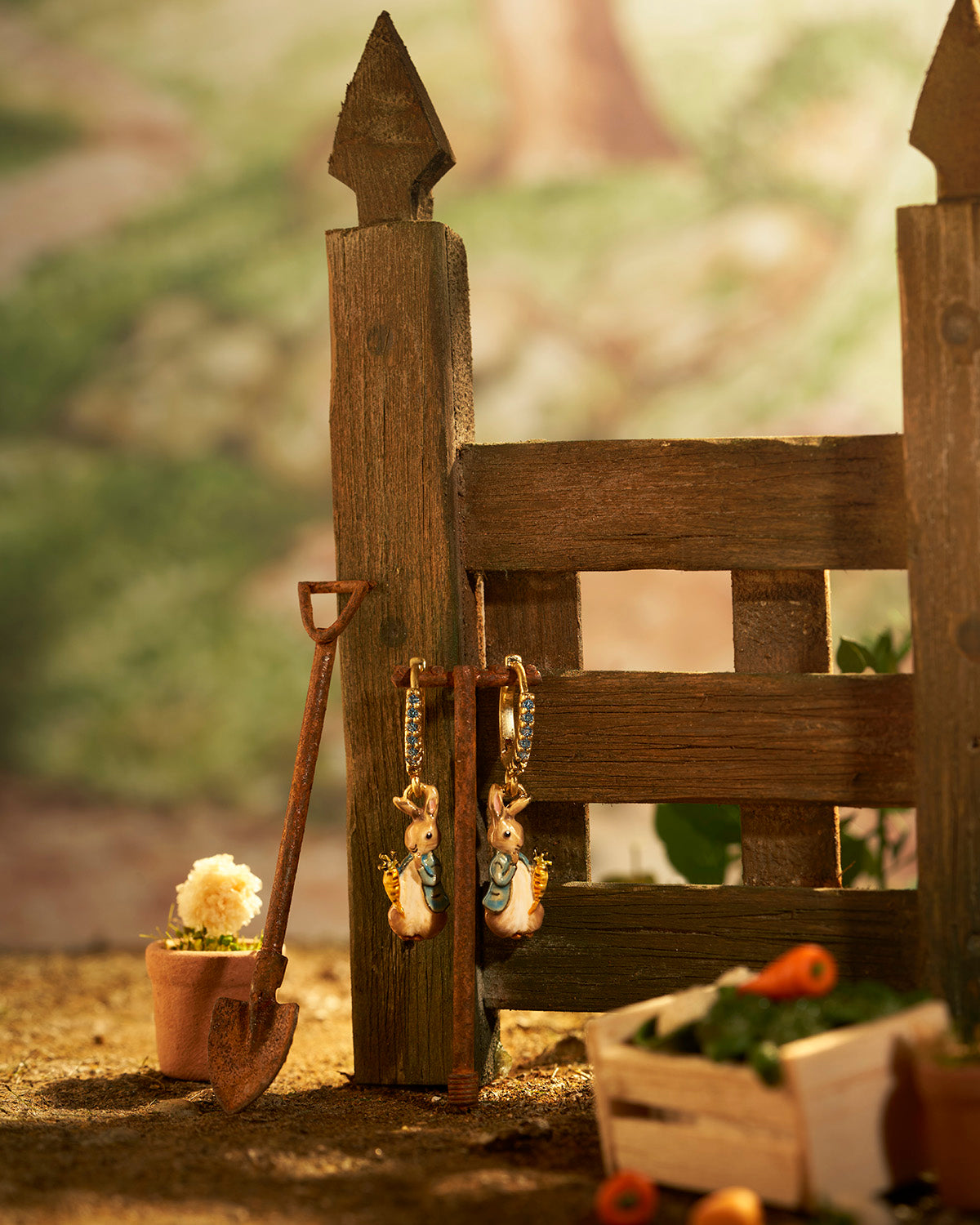 Wooden fence with miniature garden accessories including a shovel, pots, and figurines.